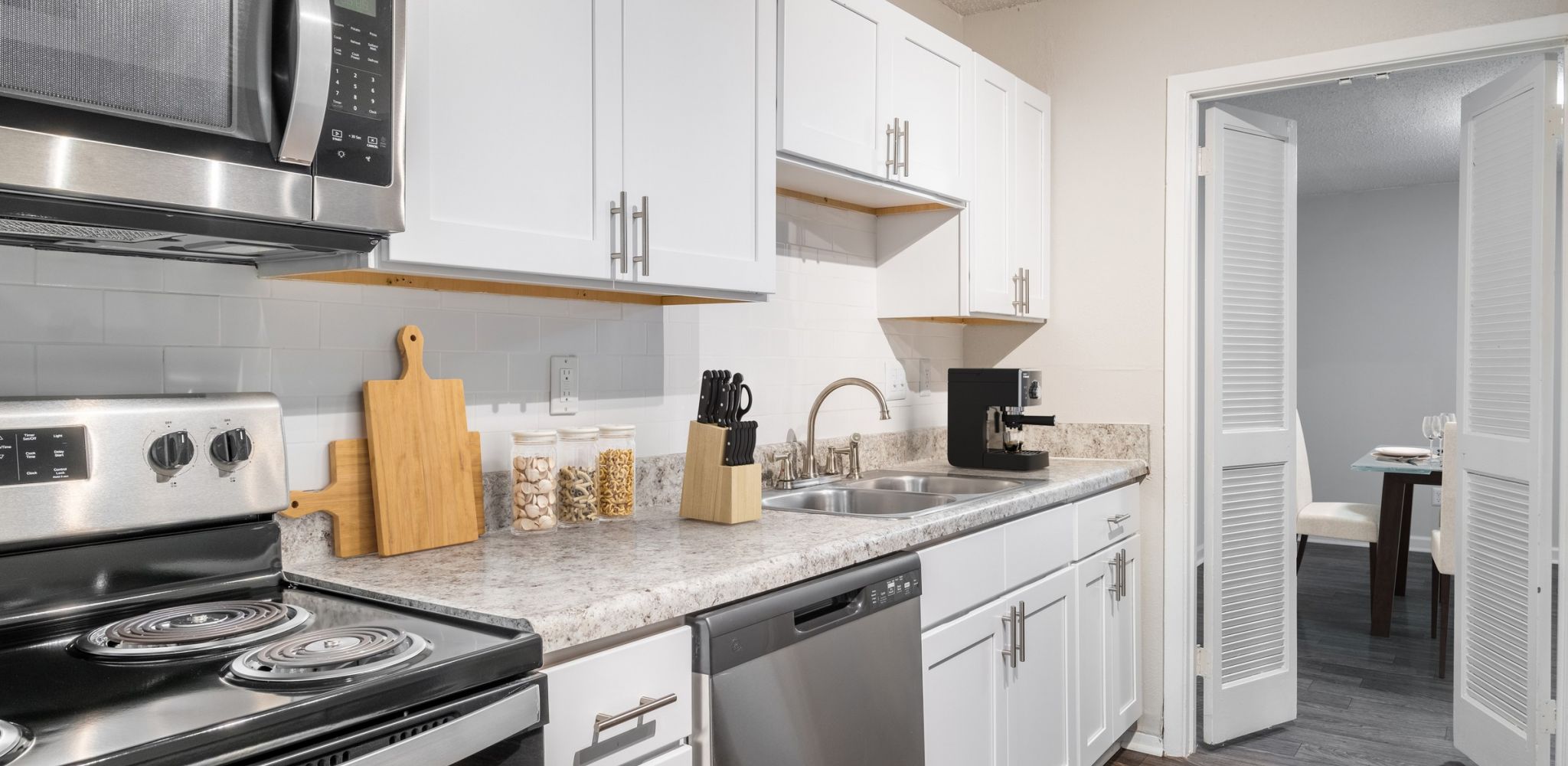 Hawthorne at Wisteria beautiful apartment kitchen with subway tile backsplash, quartz-look countertops, stainless steel appliances